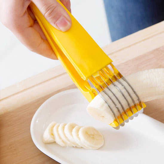 Yellow banana slicer being used to slice a banana on a white plate.