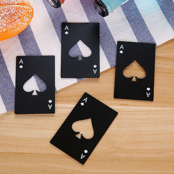 Black playing card bottle opener with a spade design on a wooden surface.