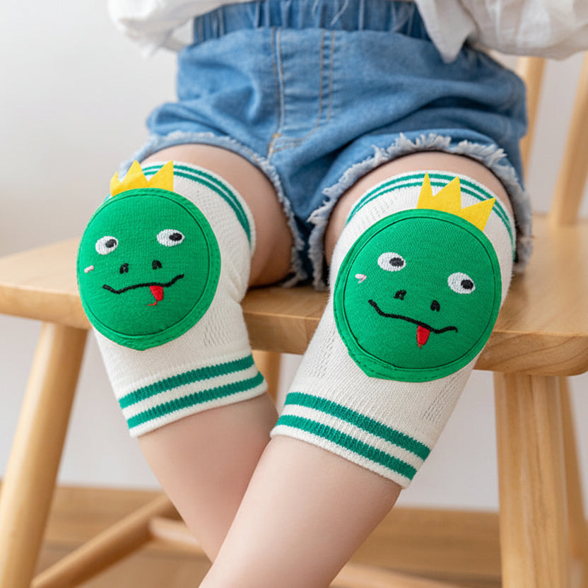 Children's green knee pads with cartoon design on a wooden chair.